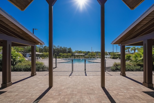 view of patio / terrace with a community pool and fence