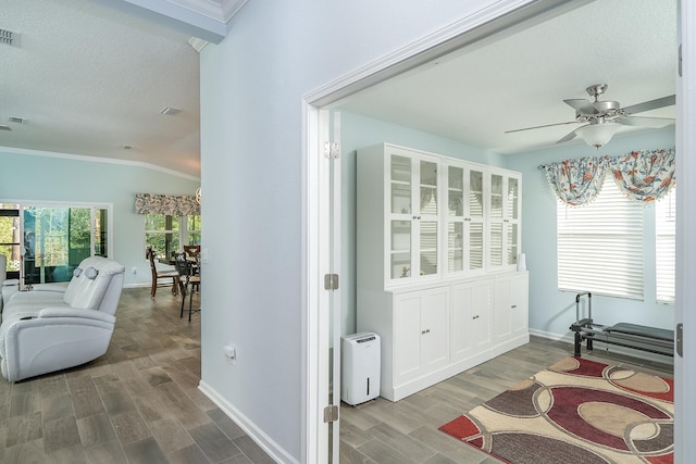 interior space with vaulted ceiling, baseboards, a ceiling fan, and wood finished floors