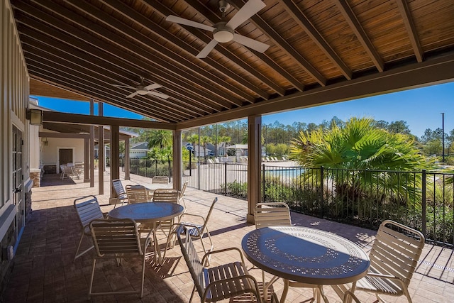 view of patio with outdoor dining area, a ceiling fan, and fence