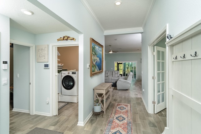 clothes washing area with a textured ceiling, ceiling fan, washing machine and dryer, and crown molding