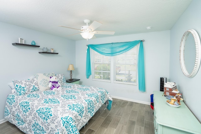 bedroom featuring a textured ceiling, ceiling fan, and dark wood-type flooring