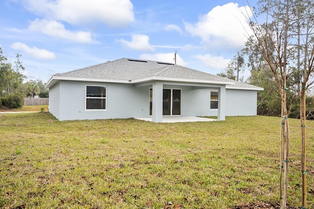 back of house with a patio area and a lawn