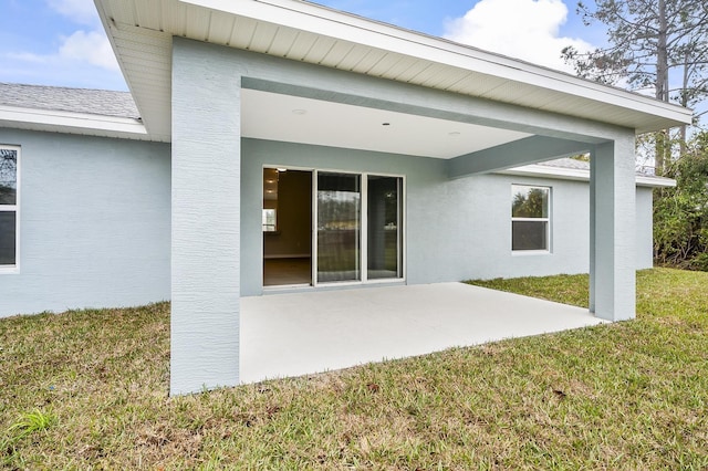 rear view of property featuring a lawn and a patio