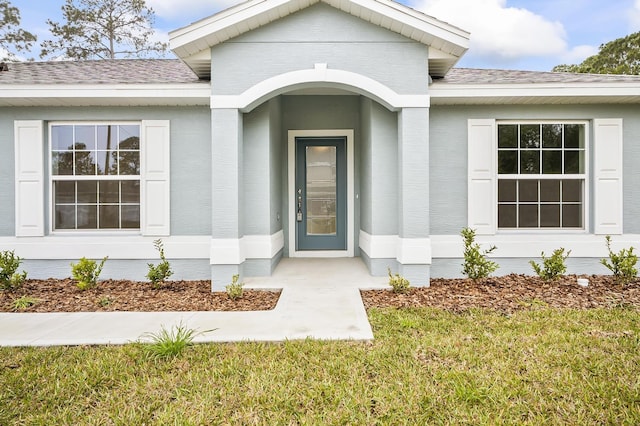 entrance to property with a lawn