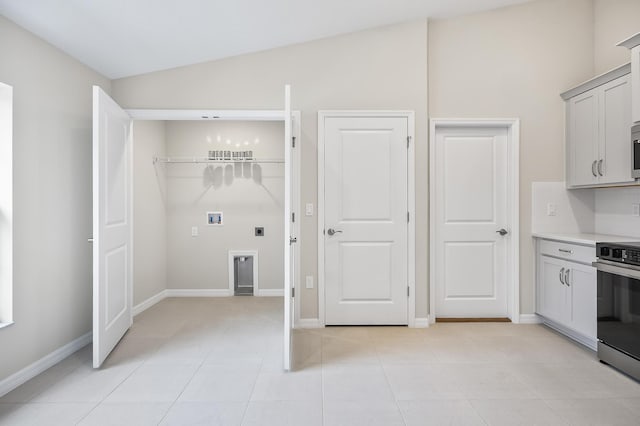 clothes washing area featuring washer hookup, electric dryer hookup, and light tile patterned flooring