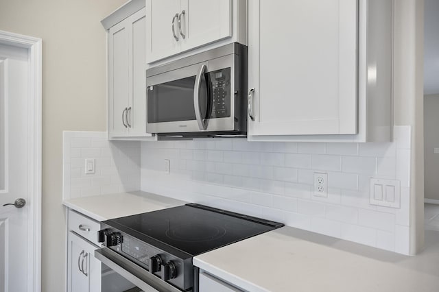 kitchen featuring white cabinetry, backsplash, and electric stove