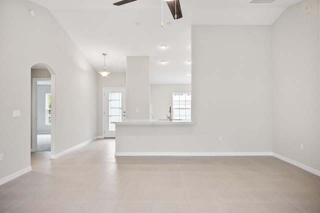 empty room featuring vaulted ceiling, sink, and ceiling fan