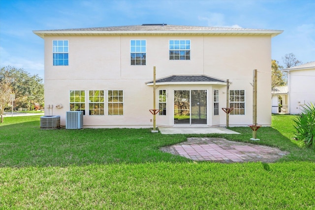 rear view of house featuring a patio, central air condition unit, and a lawn