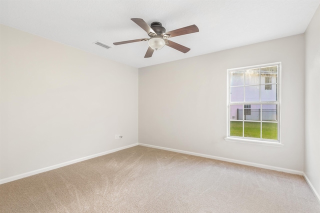 carpeted empty room featuring ceiling fan and a healthy amount of sunlight