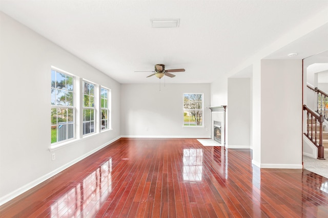 unfurnished living room with ceiling fan, dark hardwood / wood-style flooring, and plenty of natural light