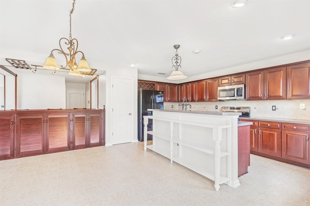 kitchen with hanging light fixtures, an inviting chandelier, backsplash, a kitchen island, and appliances with stainless steel finishes