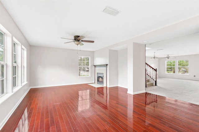 4905 Cypress Links Blvd, Elkton, FL 32033 - unfurnished living room featuring a ceiling fan, stairway, wood finished floors, and a tile fireplace