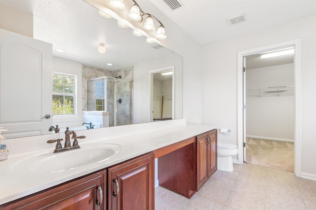 bathroom featuring tile patterned flooring, a shower with door, vanity, and toilet