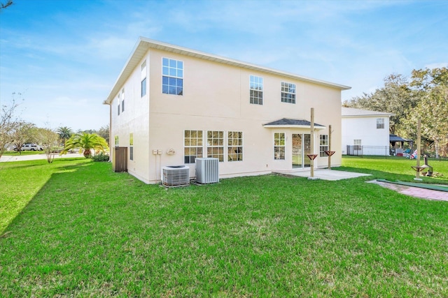 back of property with central air condition unit, a yard, and a patio