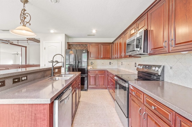 kitchen featuring pendant lighting, decorative backsplash, sink, and appliances with stainless steel finishes