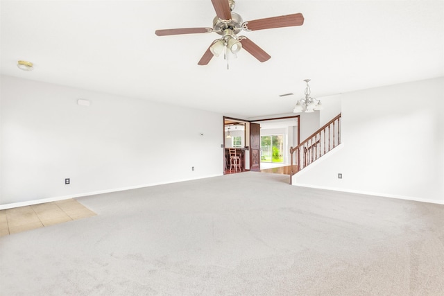 empty room with carpet flooring and ceiling fan with notable chandelier