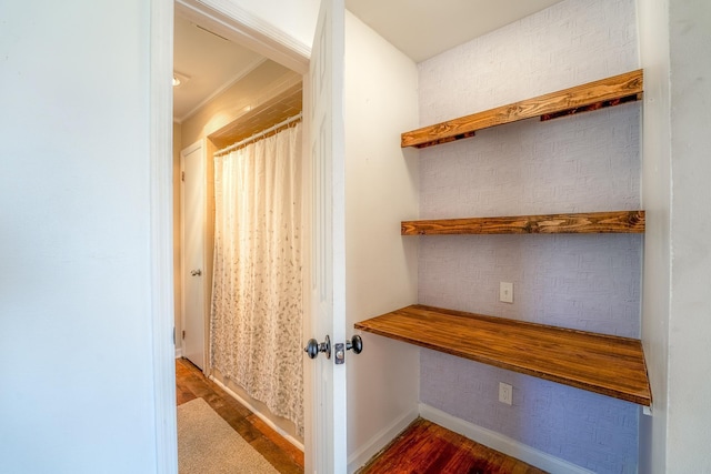 interior space featuring baseboards and wood finished floors