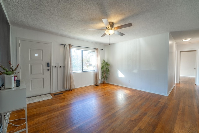 entryway featuring ceiling fan, a textured ceiling, wood finished floors, and visible vents