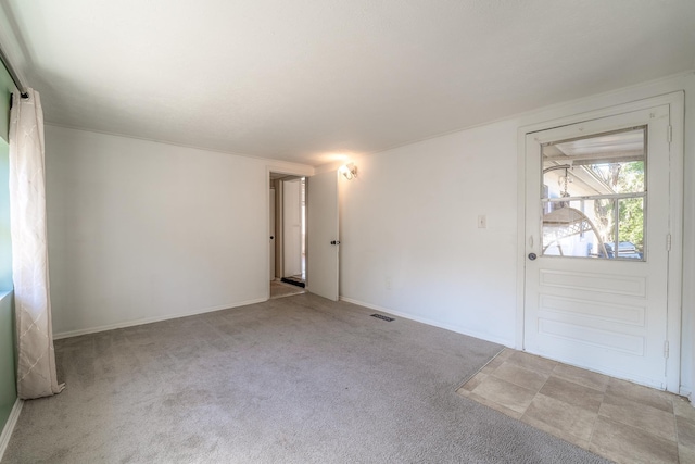 unfurnished room featuring carpet, visible vents, and baseboards