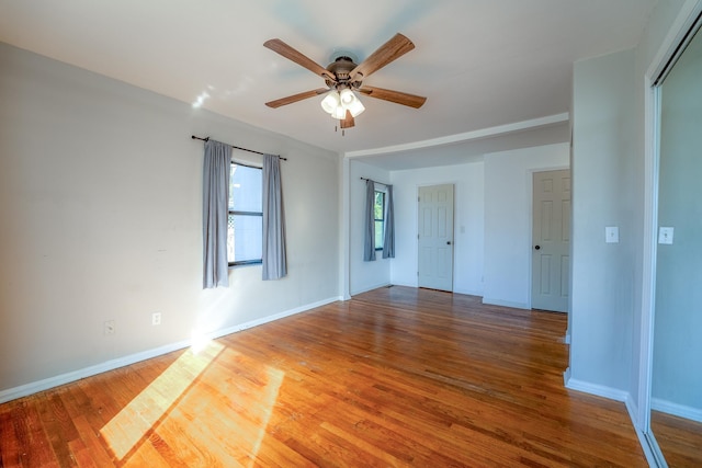 spare room with baseboards, a ceiling fan, and wood finished floors