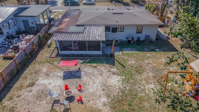 back of property with cooling unit, a sunroom, and a fenced backyard