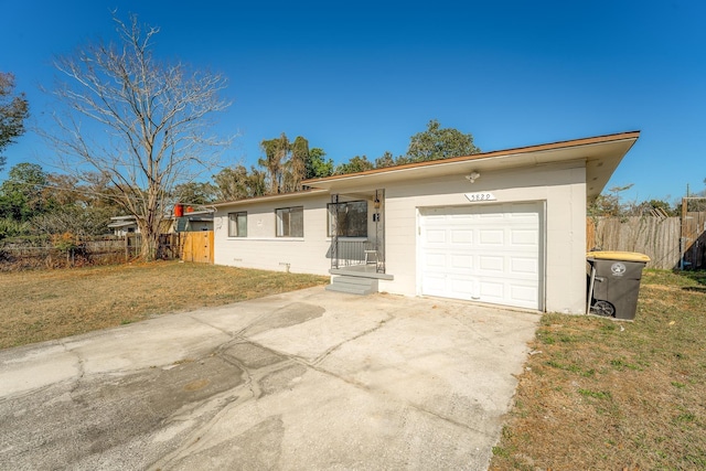 ranch-style house with a garage, concrete driveway, a front yard, and fence