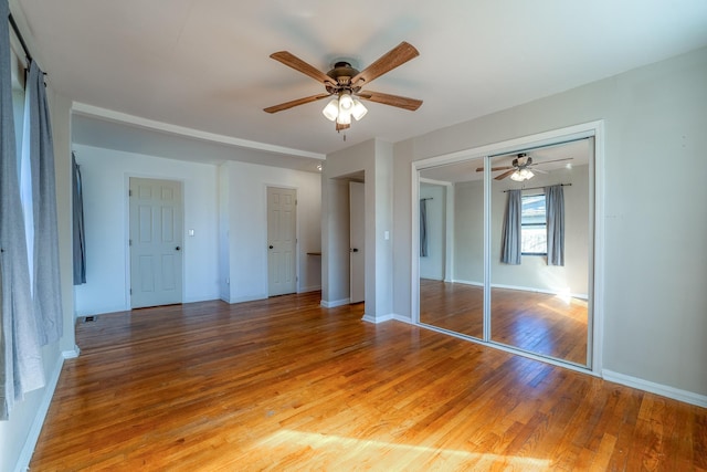 unfurnished bedroom with a ceiling fan, a closet, baseboards, and light wood finished floors