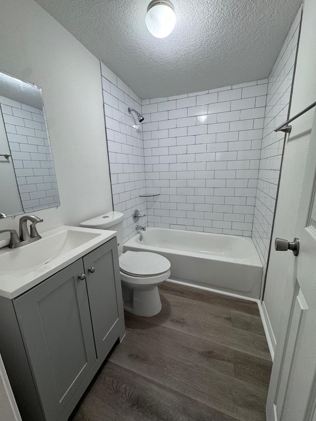 full bathroom featuring hardwood / wood-style flooring, tiled shower / bath combo, and a textured ceiling