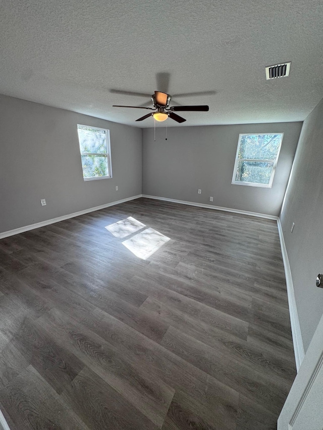 unfurnished room with a textured ceiling, dark hardwood / wood-style flooring, and ceiling fan