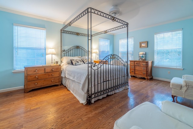 bedroom featuring ceiling fan, crown molding, and wood-type flooring