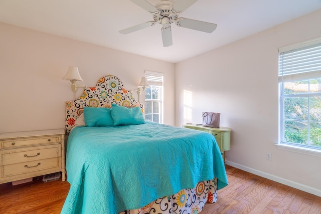 bedroom featuring multiple windows, light hardwood / wood-style floors, and ceiling fan