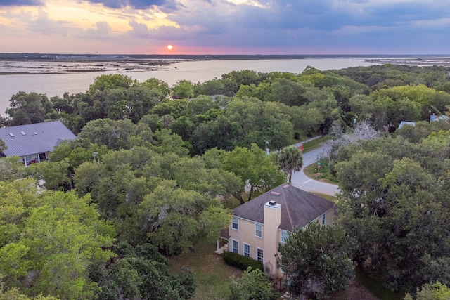 aerial view at dusk featuring a water view