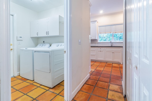 washroom featuring cabinets, sink, crown molding, and washing machine and clothes dryer