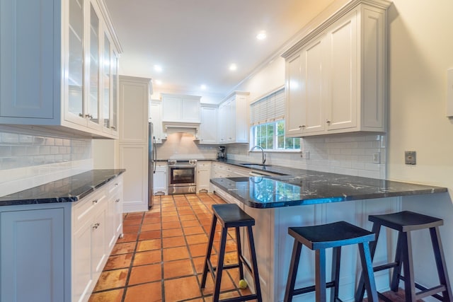 kitchen with decorative backsplash, stainless steel appliances, crown molding, sink, and white cabinetry