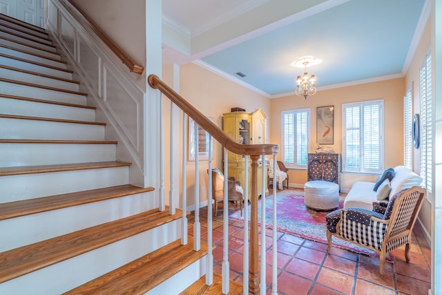 stairs with an inviting chandelier and crown molding