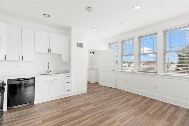 kitchen with a sink, visible vents, light countertops, dishwasher, and light wood finished floors