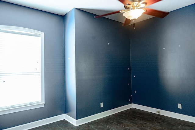 unfurnished room featuring ceiling fan and baseboards