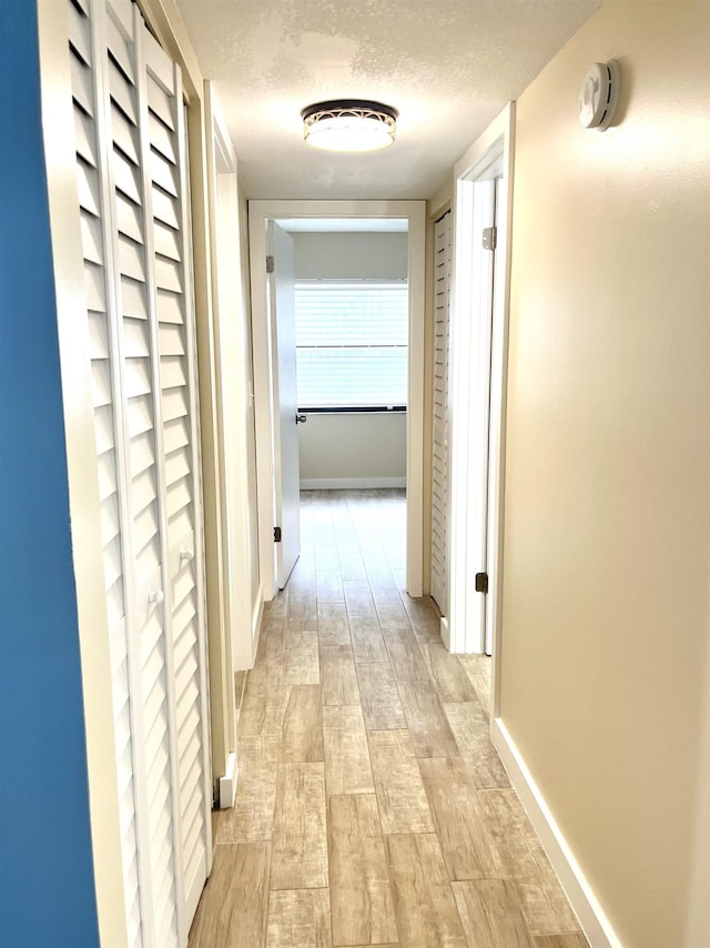 9 Alcira Ct, Saint Augustine, FL 32086 - corridor with baseboards, light wood-type flooring, and a textured ceiling