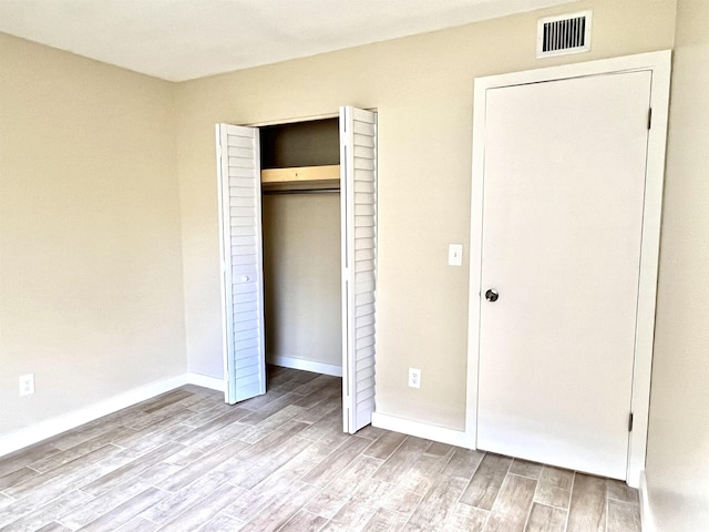9 Alcira Ct, Saint Augustine, FL 32086 - unfurnished bedroom featuring baseboards, visible vents, a closet, and wood finished floors