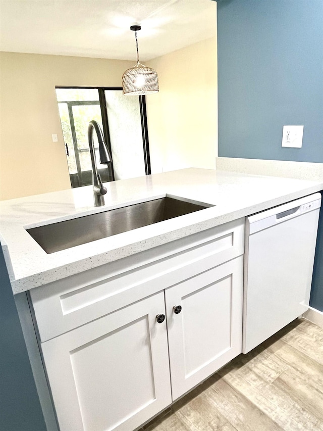 9 Alcira Ct, Saint Augustine, FL 32086 - kitchen featuring white cabinets, light wood-style flooring, a sink, pendant lighting, and white dishwasher