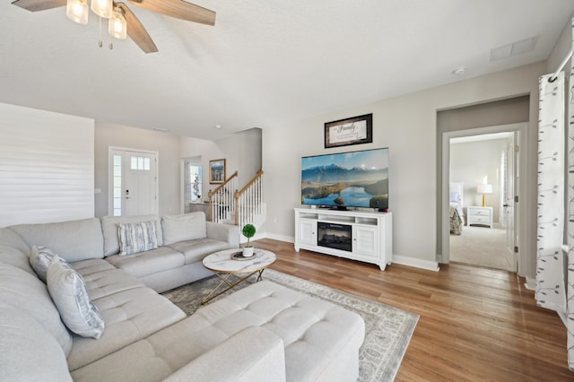 living room featuring ceiling fan and hardwood / wood-style floors