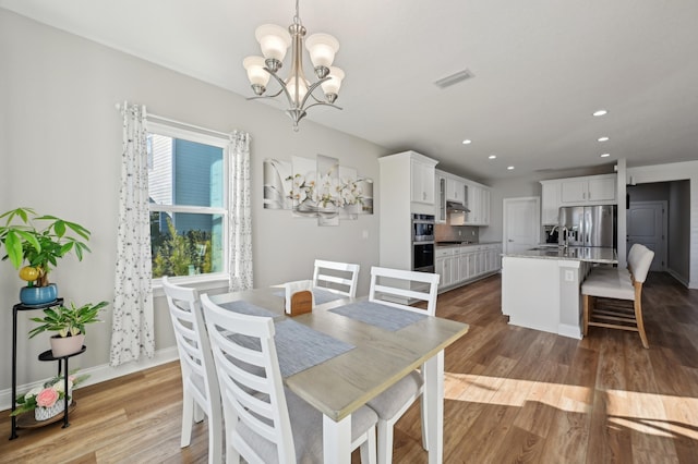 dining area with sink, light hardwood / wood-style flooring, and a wealth of natural light