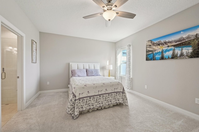 carpeted bedroom featuring a textured ceiling, ceiling fan, and ensuite bathroom