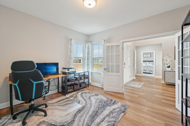 office space with light hardwood / wood-style floors and a textured ceiling