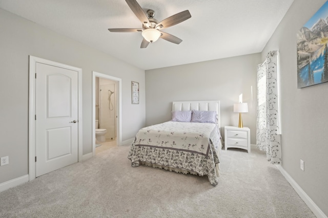 bedroom with ensuite bath, light colored carpet, and ceiling fan