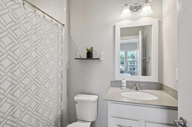 bathroom featuring vanity, a shower with shower curtain, and toilet