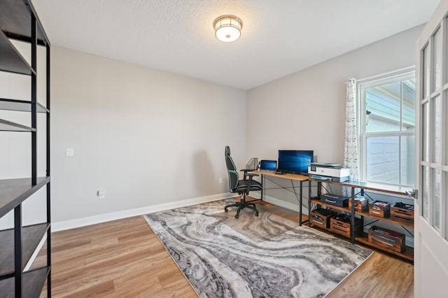 home office with hardwood / wood-style flooring and a textured ceiling