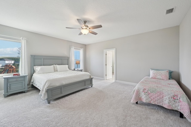 bedroom with light carpet, a textured ceiling, and ceiling fan