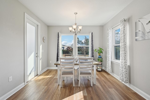 dining room with hardwood / wood-style flooring and a chandelier