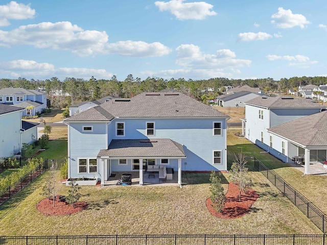 back of house with a lawn and a patio